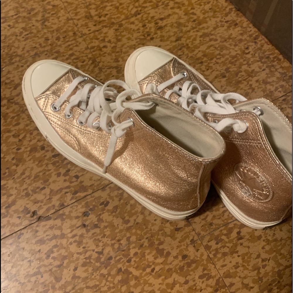 Gold high top Chuck Taylor Converses